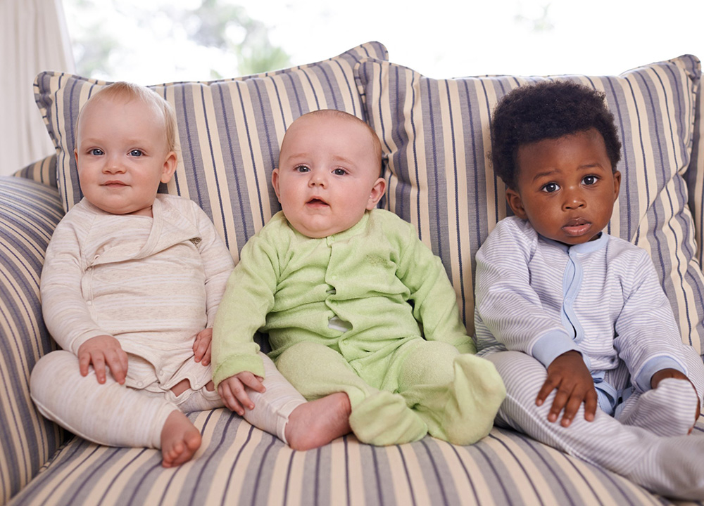 Cute babies on a couch.