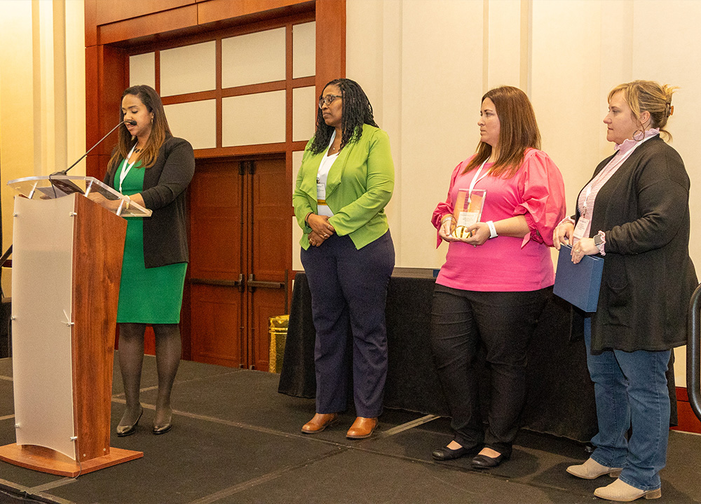 Attendees at an Immunization Program conference giving a speech.