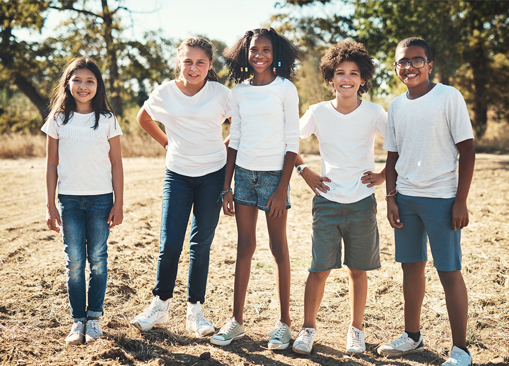 A group of older schoolchildren dressed in white t-shirts and jeans